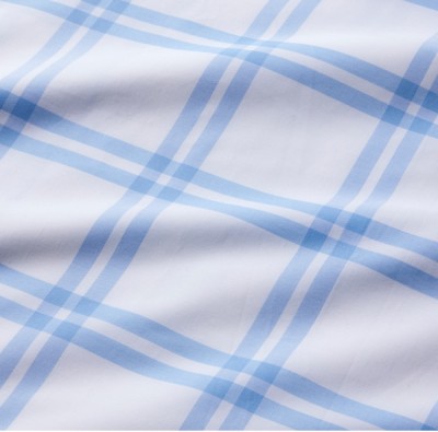 A close up detail of a blue and white plaid bed sheet.