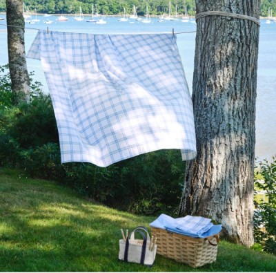 A bedspread blows in the breeze on a clothesline outside.