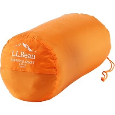 An orange cylindrical bag with the text L L Bean PUFFER BLANKET ZIG ZAG printed on it.