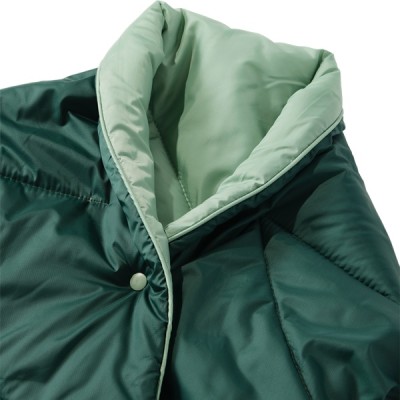 A green, quilted blanket with green inner lining and snap buttons which can be worn as a cape.