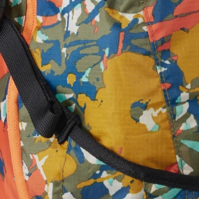 A close-up of multi colored fabric with a textured strap running diagonally across it. 