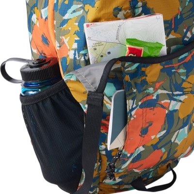 A multi blue backpack's shove it side pocket containing a water bottle.