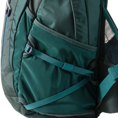 A green backpack with multiple pockets and straps. 