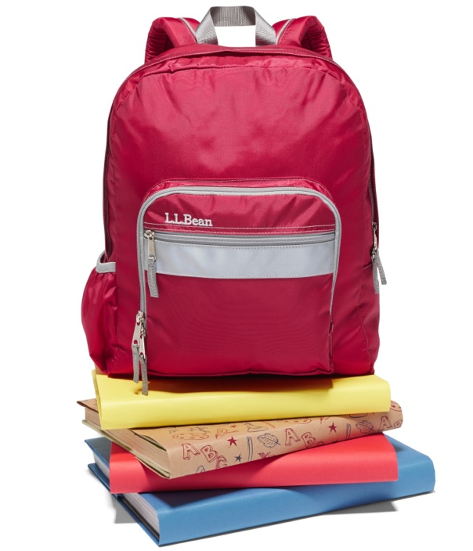 Red L. L. Bean school backpack sitting on top of a small stack of books.