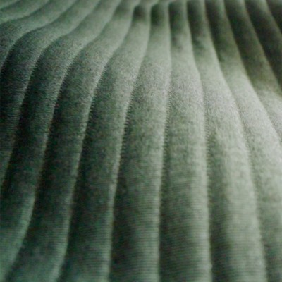 Close-up of ribbed green fabric showing ultralight quilted texture and curved channel stitching. 