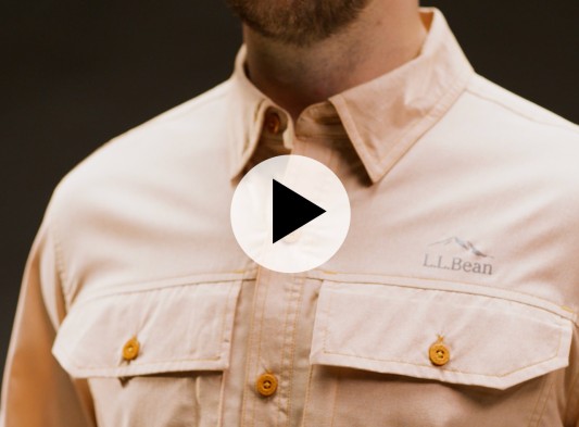 Close up of a person wearing a light tan L L Bean button up shirt with two chest pockets; video play icon overlay. 
