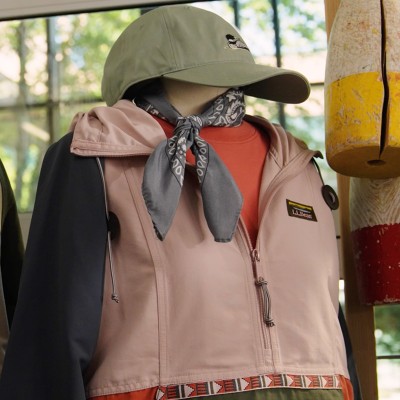Mannequin wearing a color-blocked L L Bean anorak, cap, and bandana neck scarf in a rustic store display.