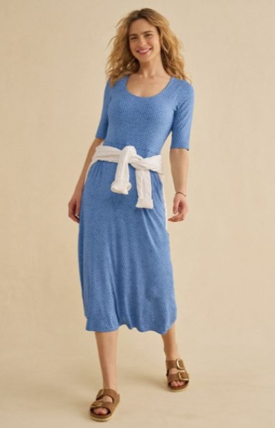 Blue midi dress with half‑length sleeves, a white sweater tied at the waist, and sandals.