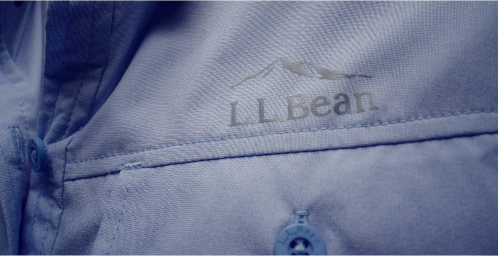 Close up image of a blue L. L. Bean shirt with the logo above the pocket.