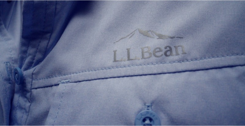 Close up image of a blue L. L. Bean shirt with the logo above the pocket.