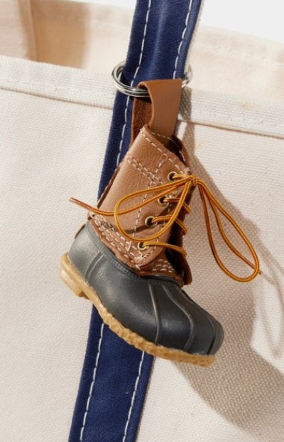 Miniature L. L. Bean Boot keychain attached to a blue tote strap.