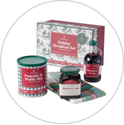 A holiday breakfast gift set featuring pancake and waffle mix, blueberry syrup, blueberry jam and a plaid tea towel.