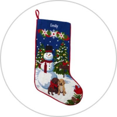A needlepoint stocking featuring a snowman, wreath and dogs with the name Emily monogrammed at the top.