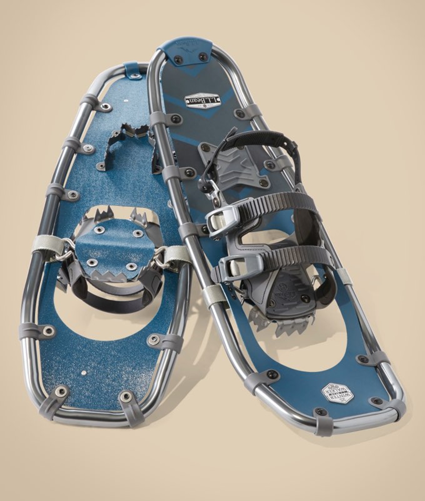 Pair of blue snowshoes with black bindings placed side by side.
