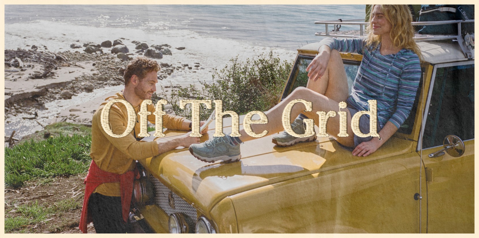 Two people sit on a yellow vehicle by a rocky coastline, with ocean waves behind them and the text “Off The Grid” overlaid.