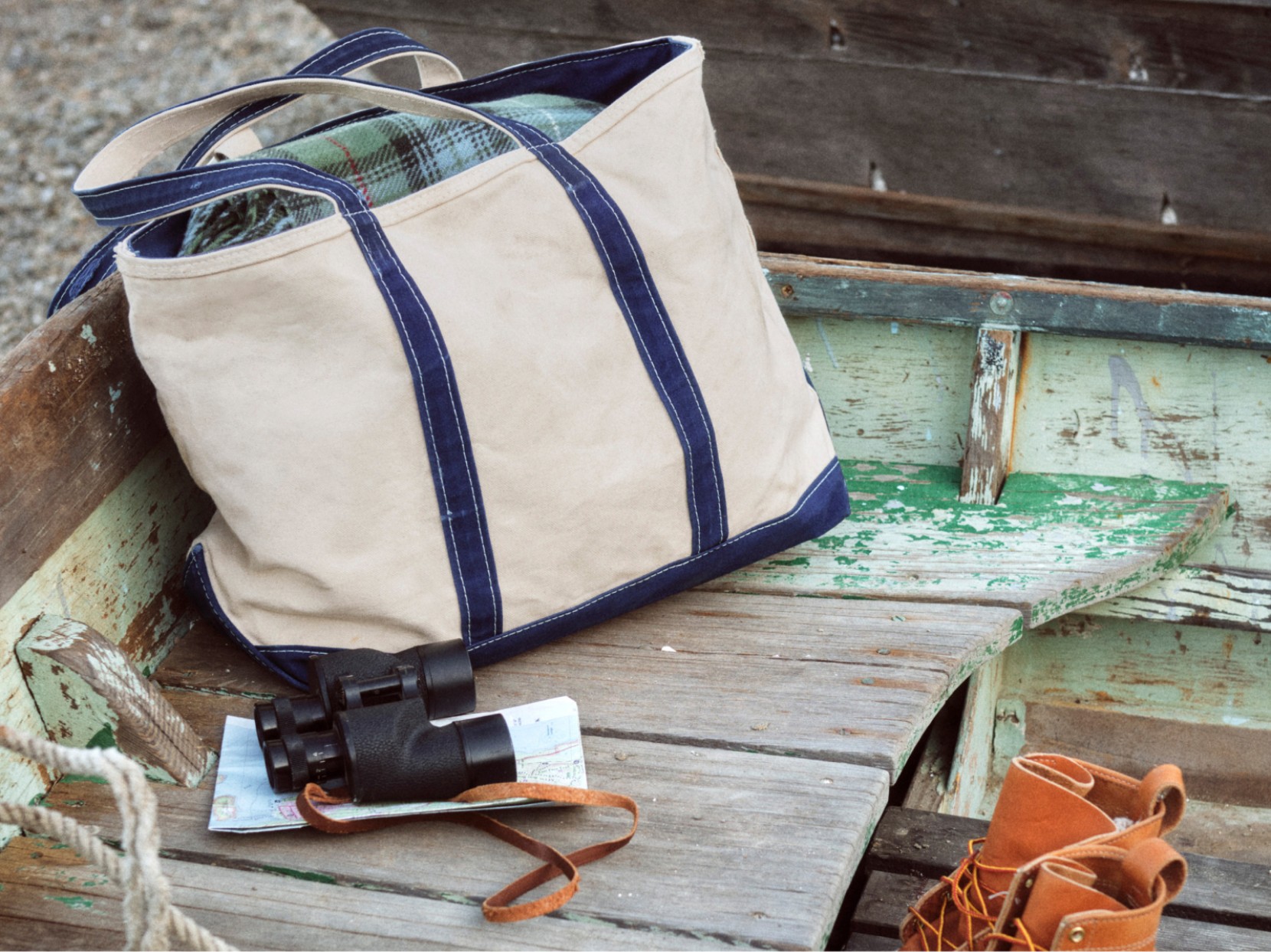 Canvas Boat & Tote bag and sunglasses resting on a weathered wooden bench.