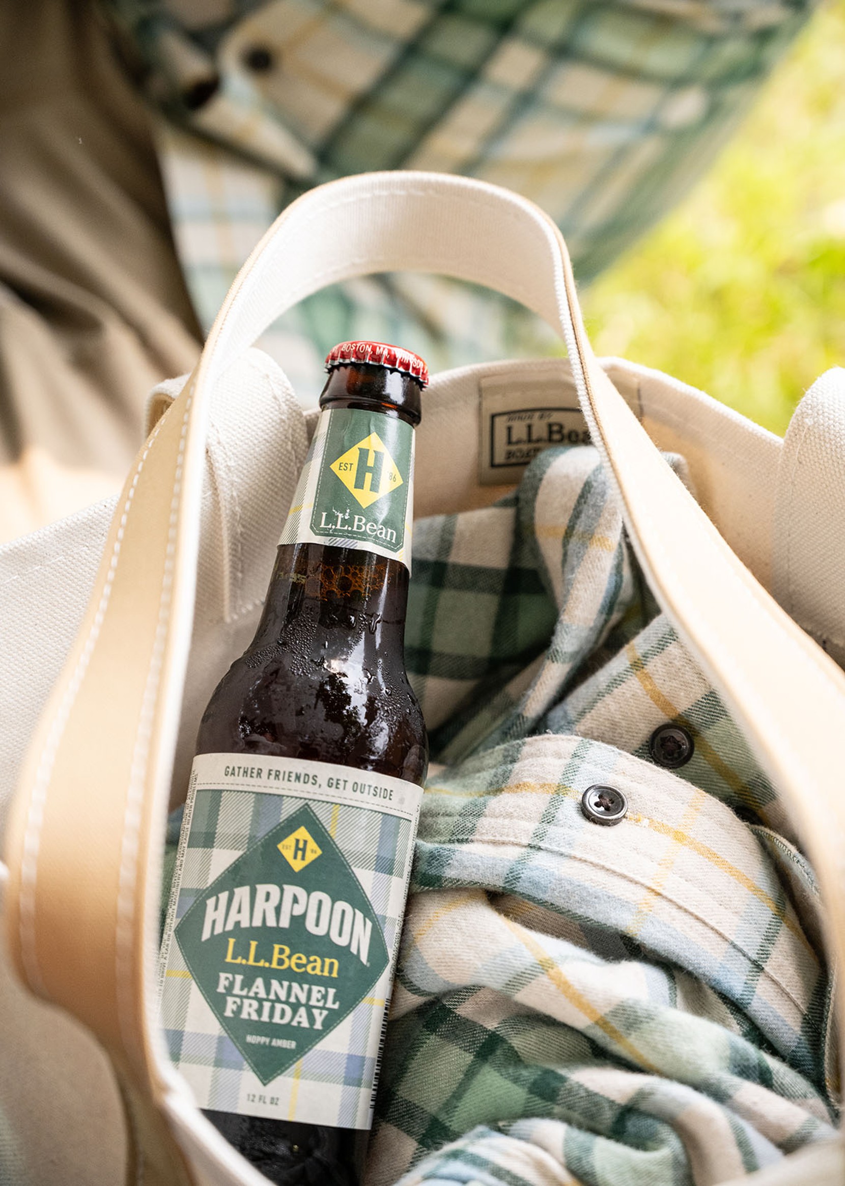 A bottle of Harpoon_L.L.Bean Flannel Friday beer in a Boat & Tote with an L.L.Bean flannel shirt.