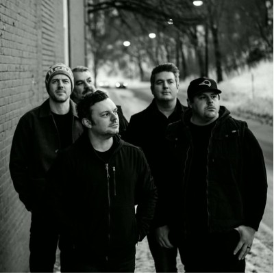 Black and white image of Toby McAllister & the Sierra Sounds, 5 people, outside by wintery road.