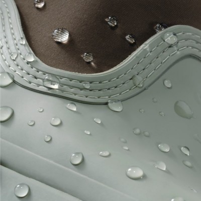 Close up image of water droplets bead on a textured, waterproof surface, highlighting its water‑resistant material.