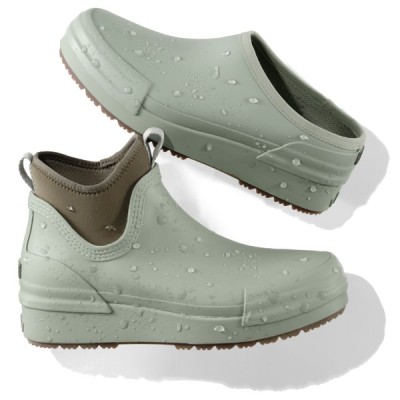 Two waterproof slip‑on boots with rugged soles are shown with water droplets on their durable surfaces.