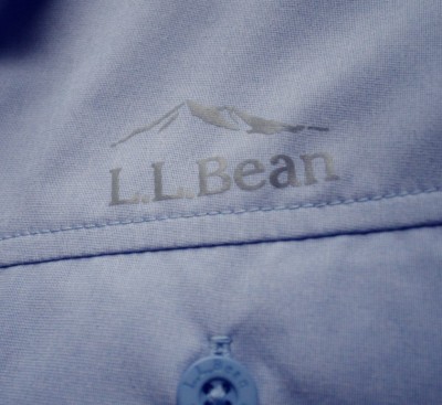 Close up image of a blue L. L. Bean shirt with the logo above the pocket.