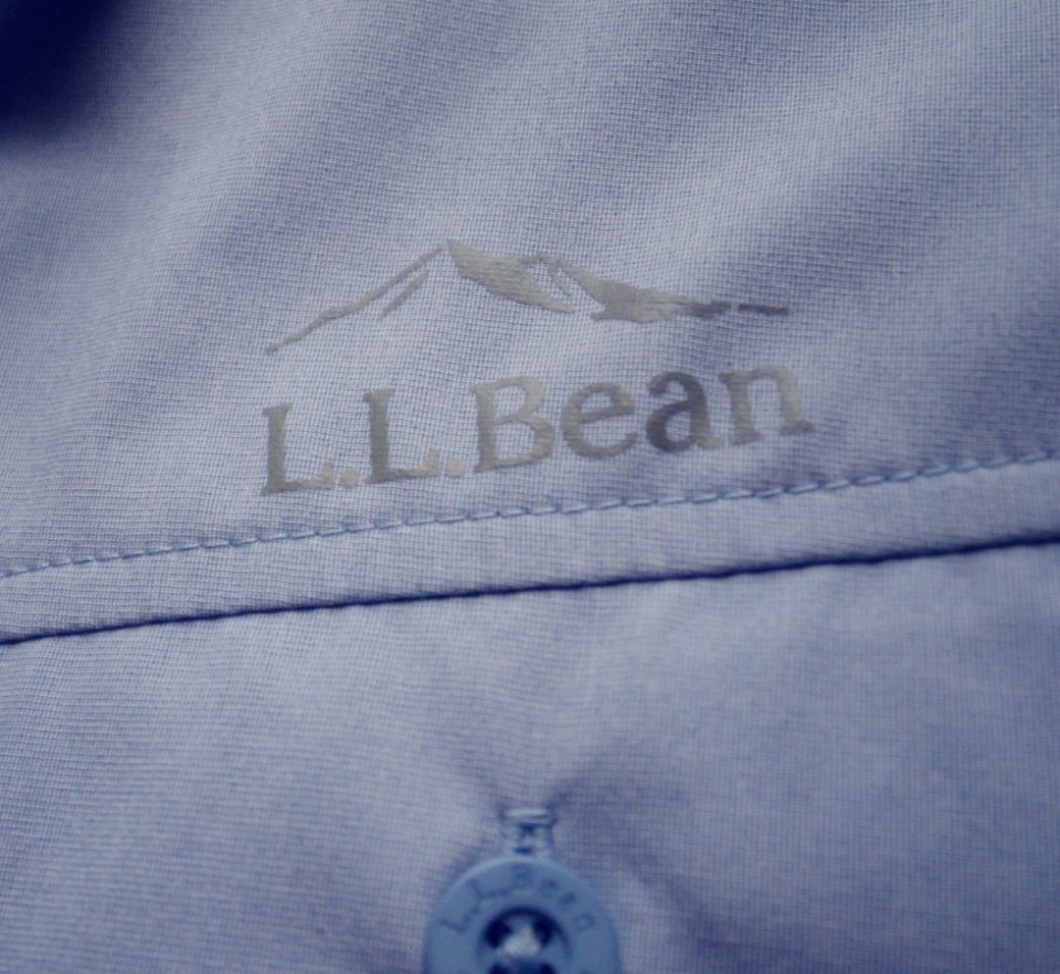 Close up image of a blue L. L. Bean shirt with the logo above the pocket.