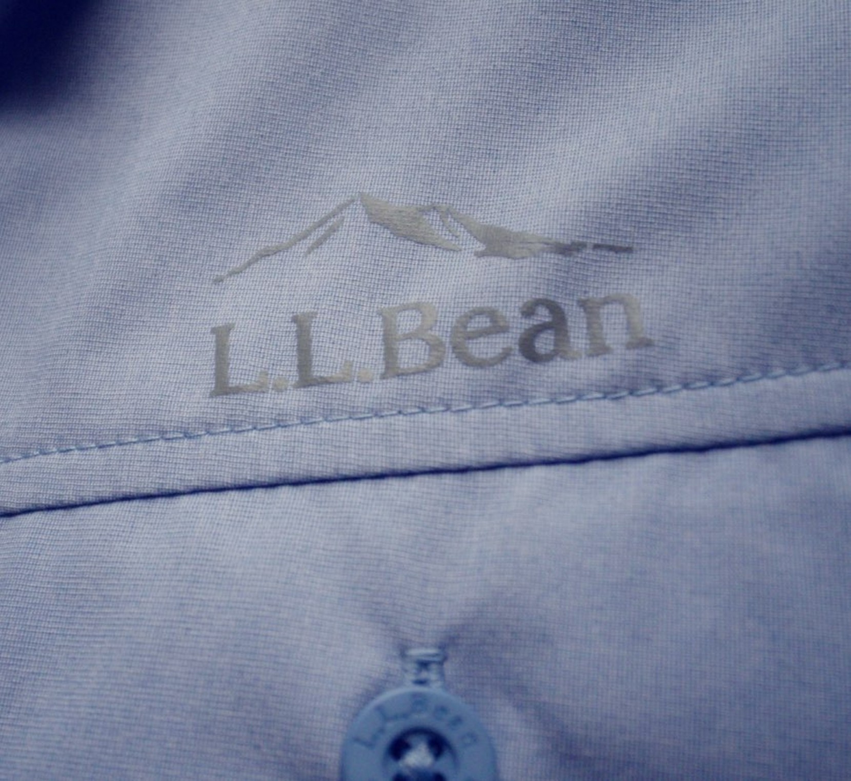 Close up image of a blue L. L. Bean shirt with the logo above the pocket.