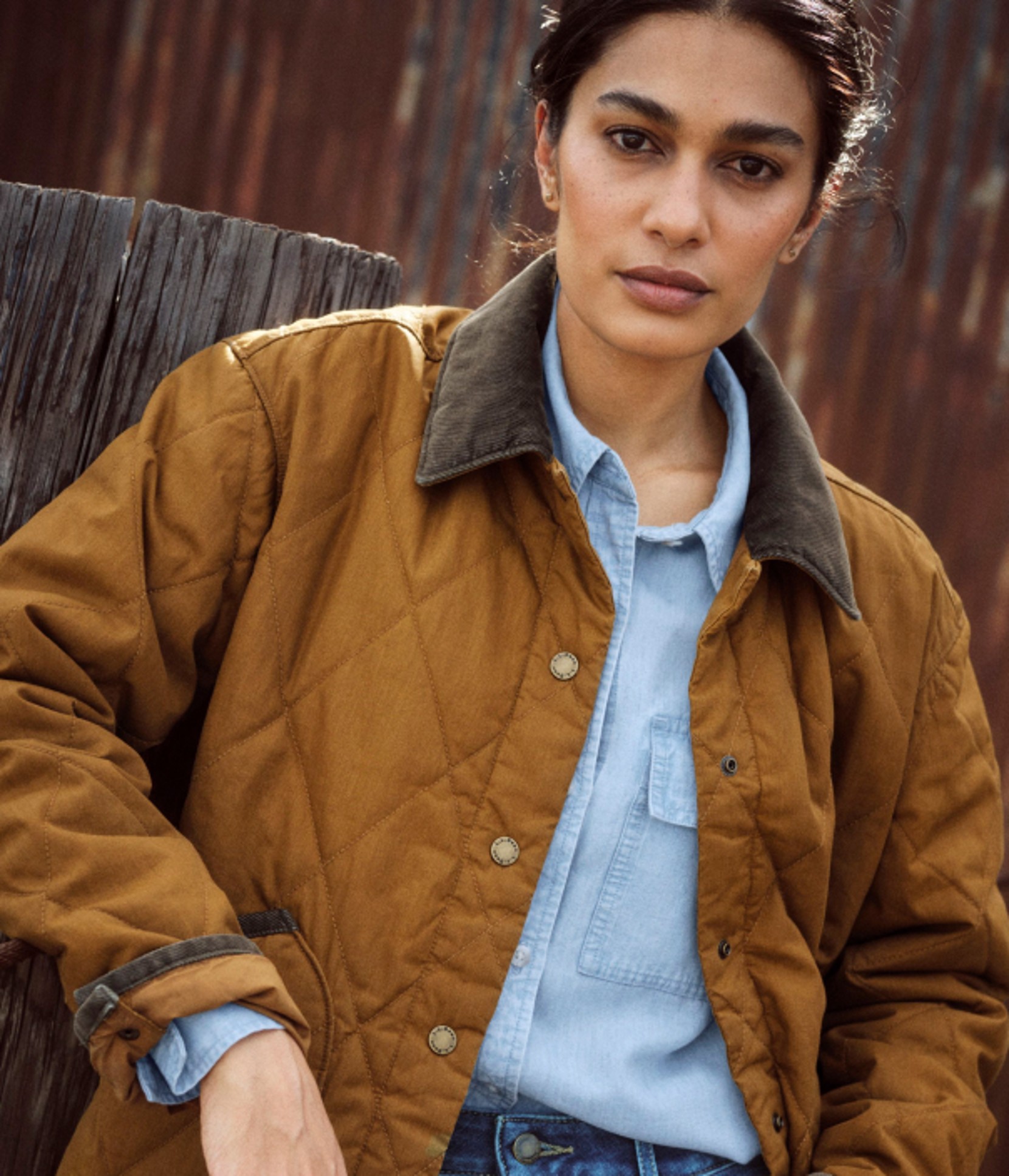 Close-up portrait of a person wearing a brown quilted jacket.