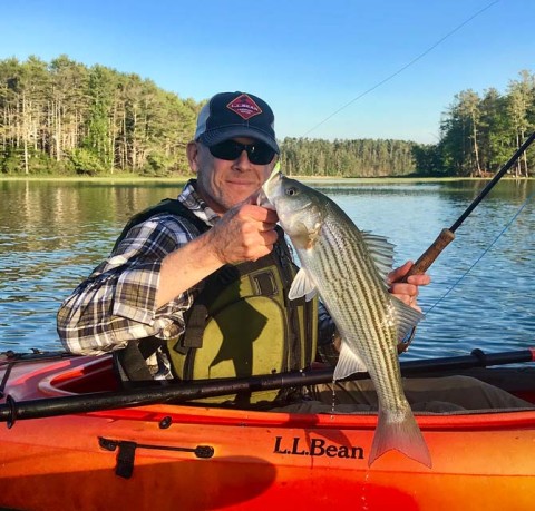 An L.L.Bean employee fishing in a kayak. 