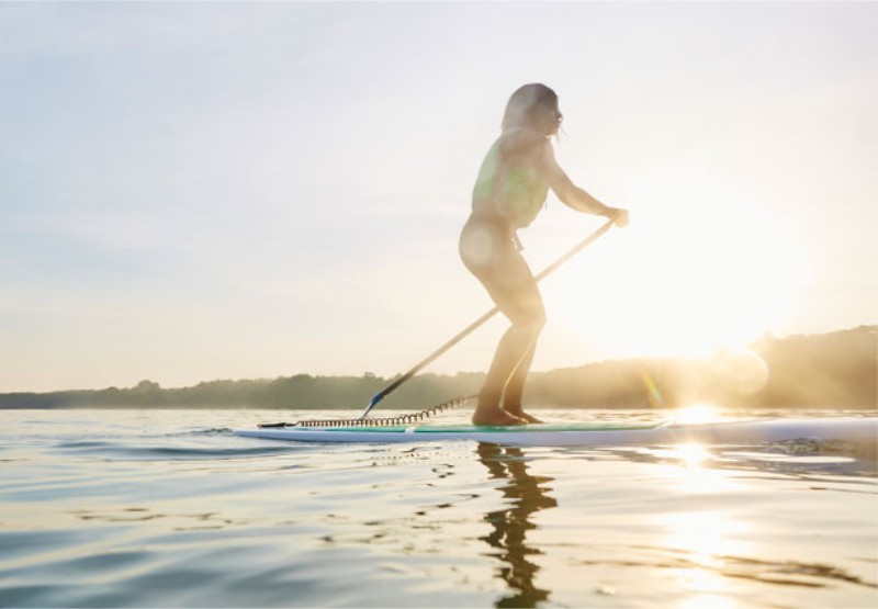 A women paddleboards during an Outdoor Discovery Schools event,