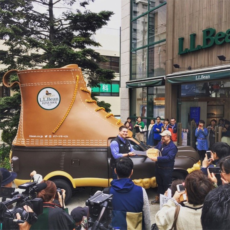 Bootmobile Driver Eddie Flaherty hands over the ceremonial “key” to commemorate the first Bootmobile arriving in Japan. 